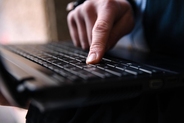 Men's hand typing on a laptop keyboard Selective focus