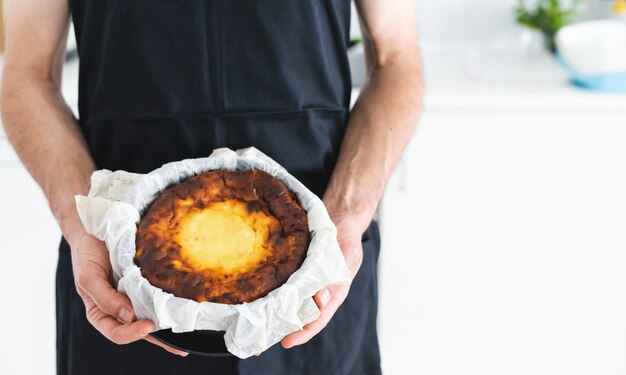 Men's hands showing a cheesecake. Kitchen concept.