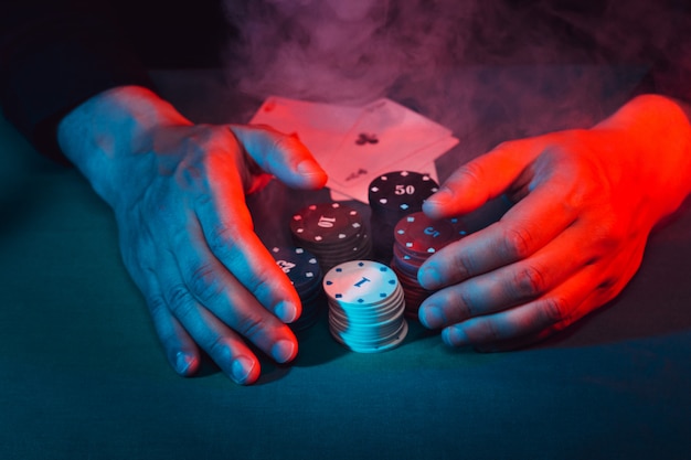 Men's hands take away the playing poker chips placed on the bet