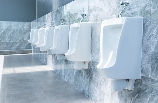 Men's room with white porcelain urinals in line in gas station