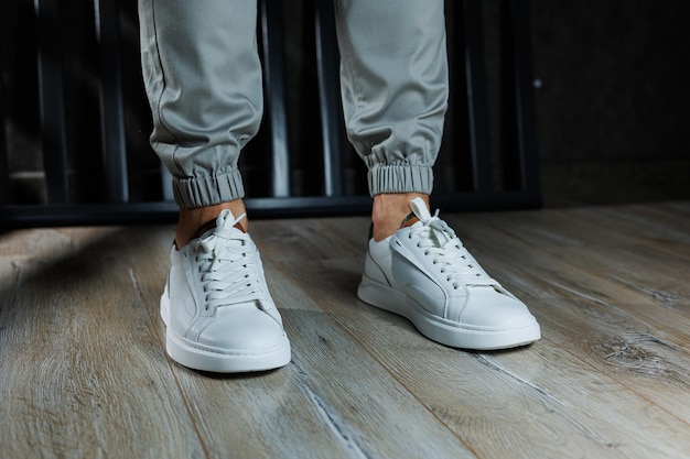 Men's summer shoes Closeup of male legs in white leather sneakers Collection of men's leather shoes