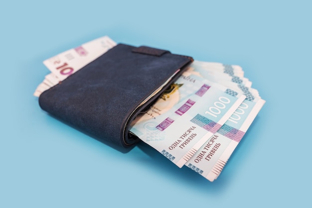 Men's wallet with Ukrainian hryvnia on a blue background