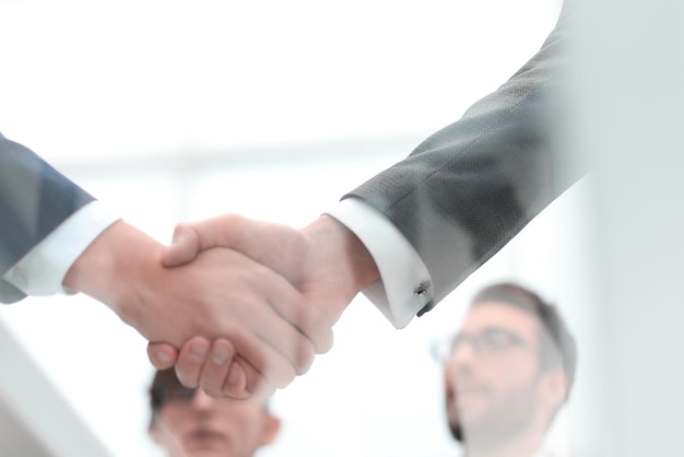 Men shaking hands with smile at office with their coworkers