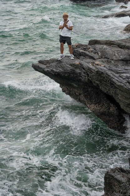 Men, tourists are taking pictures of the sea by mobile phone.