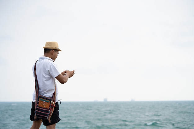 Men, tourists are taking pictures of the sea by mobile phone.