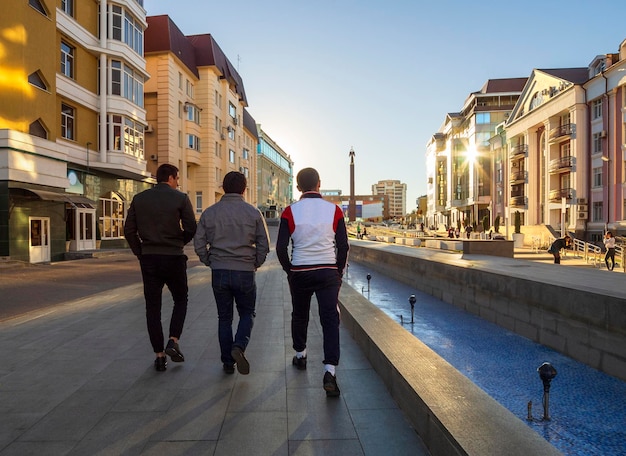 Men walk on Alexander Square with the Angel monument with a cross in the city of Stavropol Russia