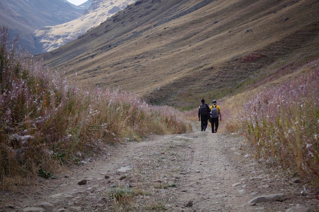 Men walk in the mountains along a dirt road