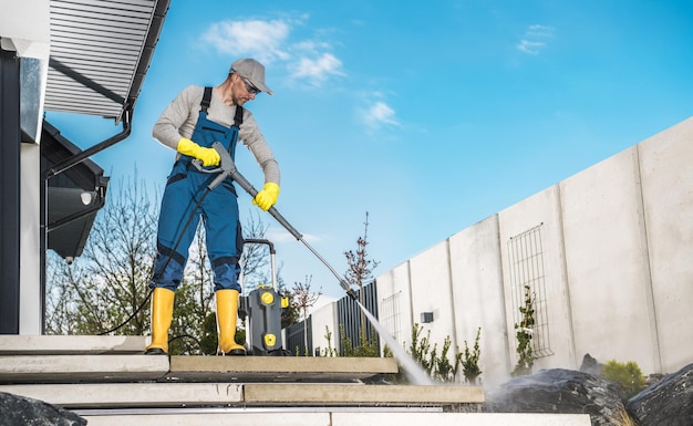 Men Washing His Backyard Garden Concrete Path and Stairs Using Pressure Washer