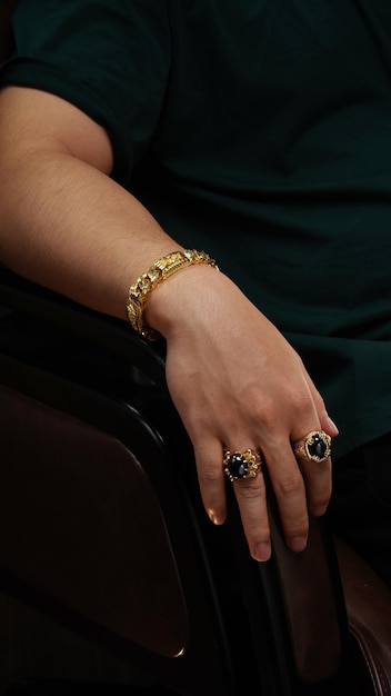 men wearing a golden bracelet on hand and rings of gold