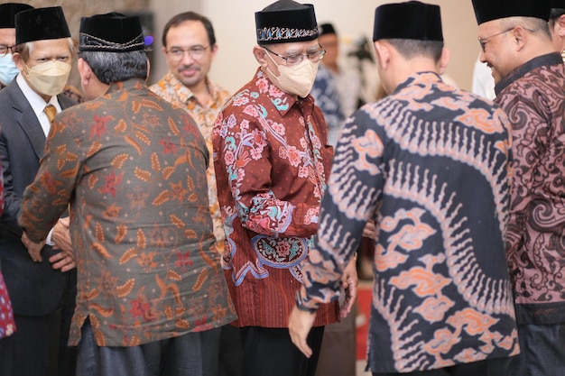 Photo men wearing traditional balinese clothing stand in a group.