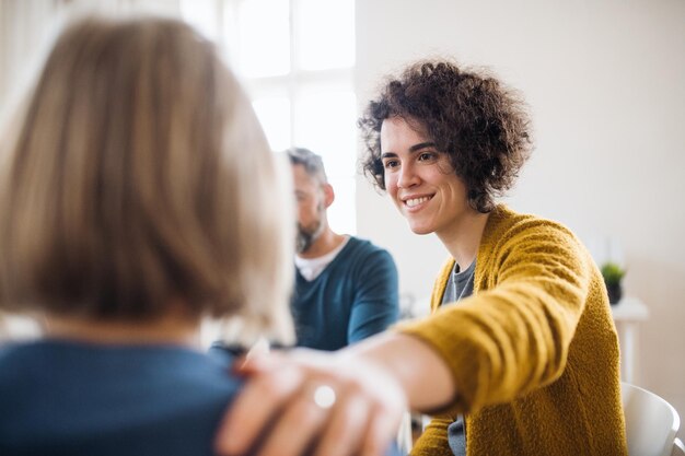 Photo men and women sitting in a circle during group therapy supporting each other