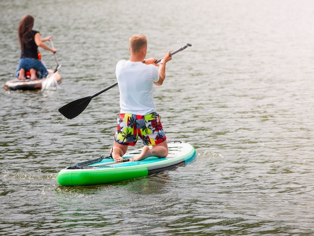 The Men and women with her baby stand up paddle boarding sup