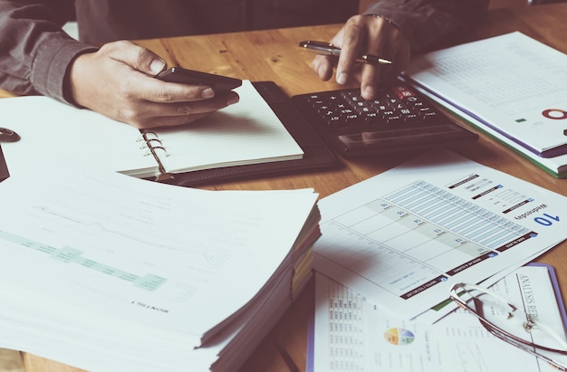 Men work with calculators and documents placed on desks