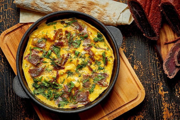 Menemen with eggs Sujuk green peppers and spices served with bread in pan Turkish breakfast