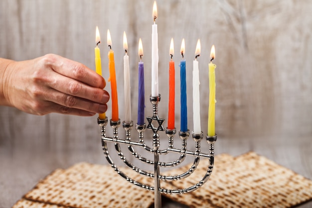 Menorah with candles for Hanukkah on a light wooden background