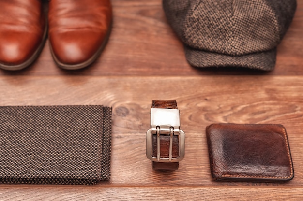 mens accessories leather shoes belt wallet cap and scarf on a wooden background