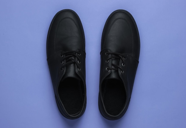 Mens leather black shoes on a purple background