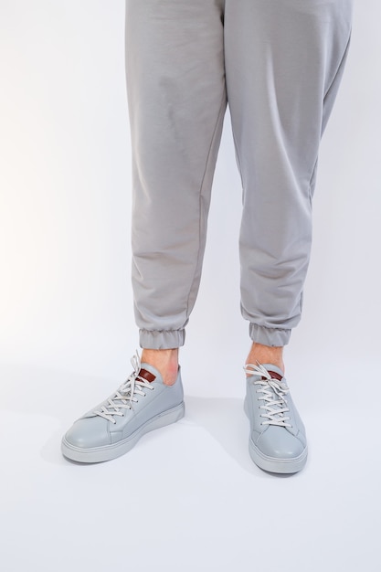 Mens sneakers on a very gray day of natural leather mens legs shoes in gray leather shoes