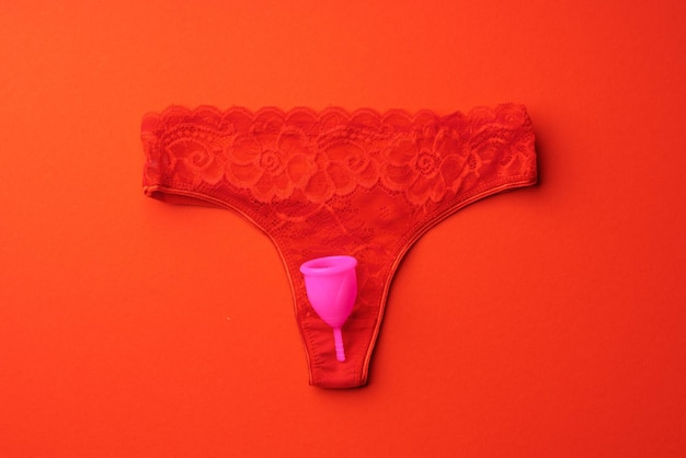 Menstrual cup and panties on paper background