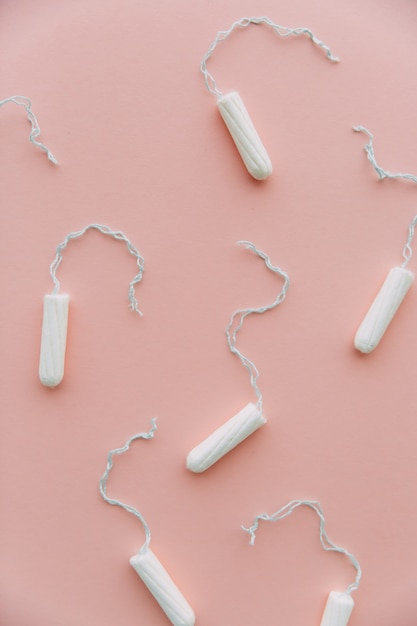 Menstrual period concept. Woman hygiene protection. Cotton tampons on pink background. Top view