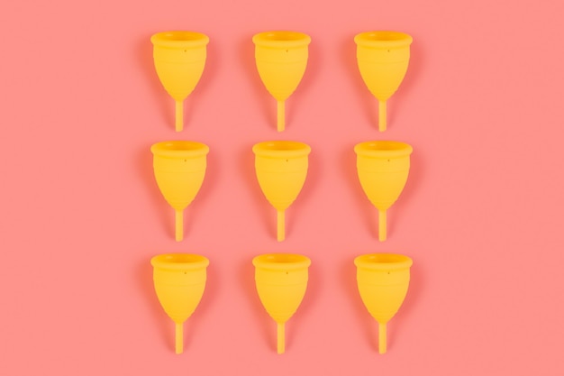 Photo menstrual yellow cups pattern on a pink background monochrome zero waste concept ecofriendly