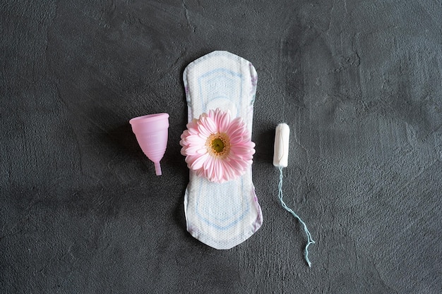 Menstruation period concept Hygienic white female pad Menstrual cup and tampon with pink flowers Menstruation protection Women's health