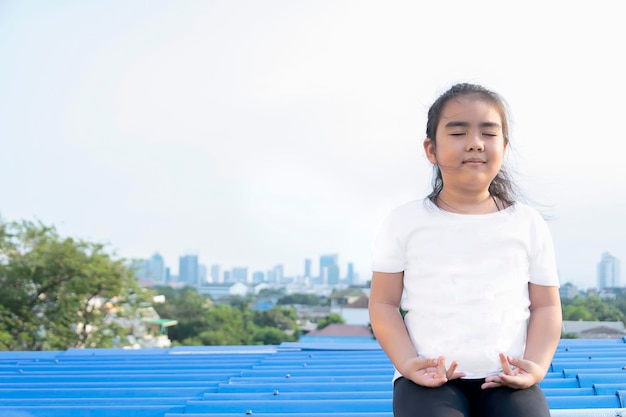 Mental developmentlifestyle conceptMeditate yoga hands of Asia Girl doing meditation HealthcareYoga AwarenessSitting on roofdeck The backyard is a building