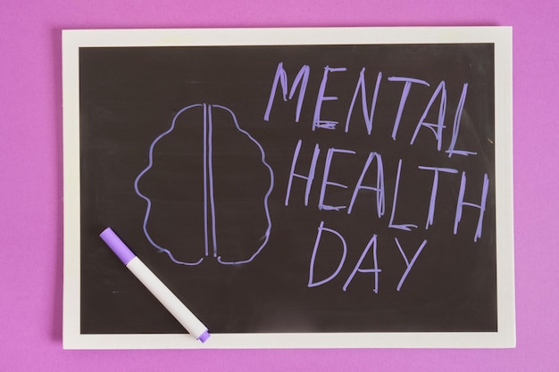 Mental health day inscription on board purple background