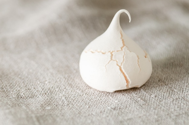 Meringue cookies with texture and cracks On a gray linen background Closeup Macro