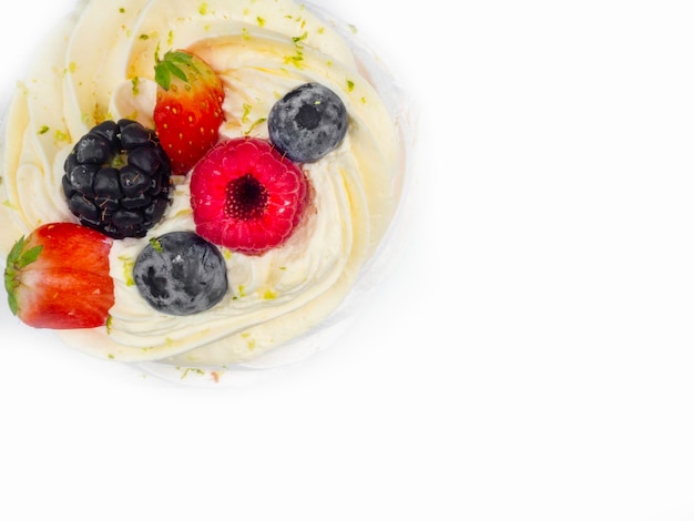 Meringue Pavlova with cream and fresh berries strawberries raspberries blueberries isolated on white