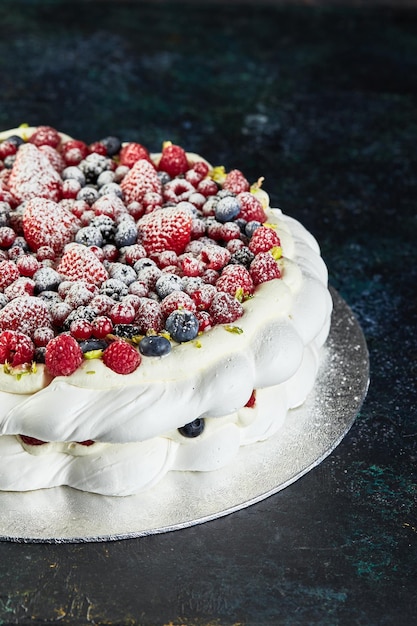 Meringue pavlova wreath cakes with whipped cream and fresh berries