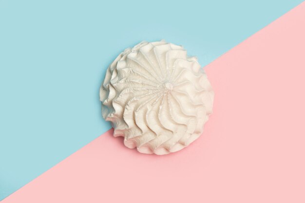 Meringue on a pink and light blue background in a top view