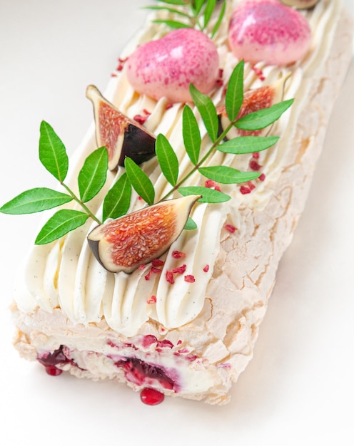 Meringue roll with cherry jam Decorated with greenery and fig slices Light background