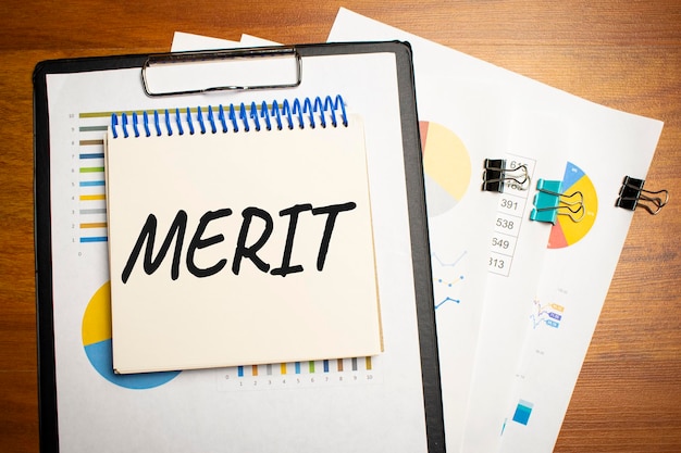 Merit is written on a notepad on an office desk