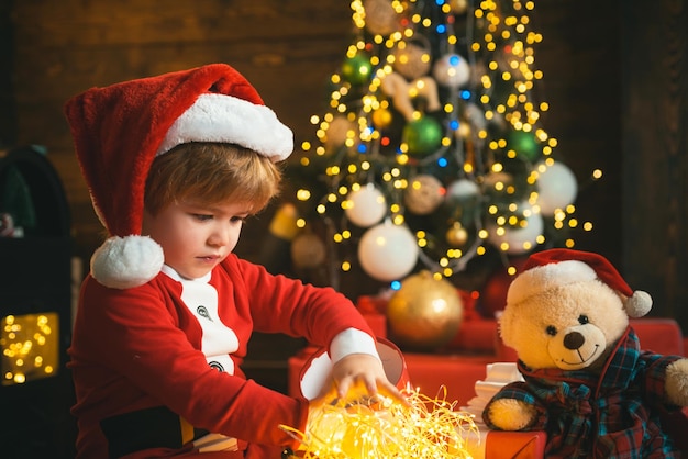 Merry and bright christmas. Childhood activity and game. Lovely baby enjoy christmas. Family holiday. Childhood memories. Santa boy celebrate christmas at home. Boy child play near christmas tree