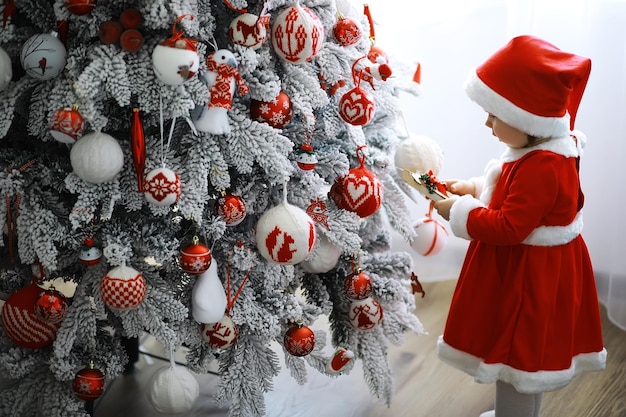 Merry bright christmas. Lovely baby enjoy christmas. Childhood memories. Santa girl little child celebrate christmas at home. Family holiday. Girl cute child cheerful mood play near christmas tree.