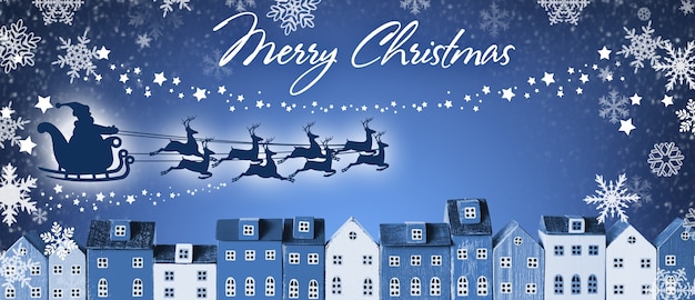 Merry Christmas Banner - Santa Claus in a sleigh and reindeer sled flies over houses of the city on blue winter background.