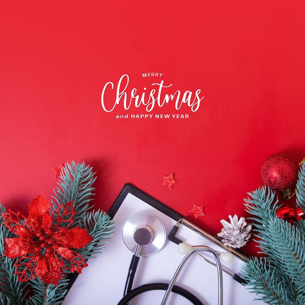 Merry Christmas greeting text with medical stethoscope and christmas decorations on red background