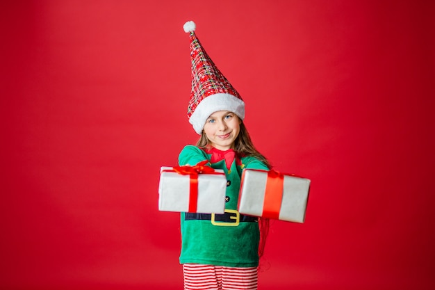 Merry Christmas, happy attractive girl with gifts in a costume of Santa Claus helper elf