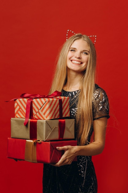 Merry Christmas a Happy Blonde Woman in a Festive Dress Holding Christmas Presents Portrait stock photoxA