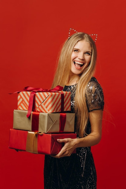 Merry Christmas a Happy Blonde Woman in a Festive Dress Holding Christmas Presents Portrait stock photoxA