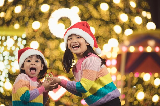 Merry Christmas happy children with a magic gift at home near Christmas tree