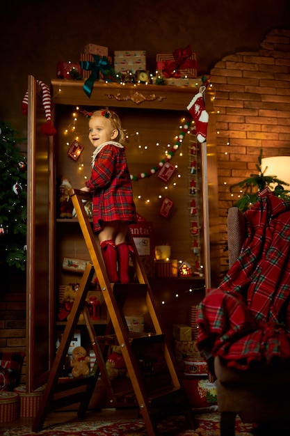 Merry christmas and happy holiday a little girl in a plaid dress