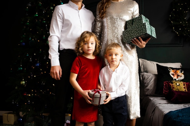 Merry Christmas and Happy Holidays Happy family with gift box near Christmas tree at home