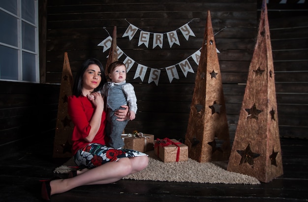 Merry Christmas and Happy Holidays! Mom and her cute son with gifts.