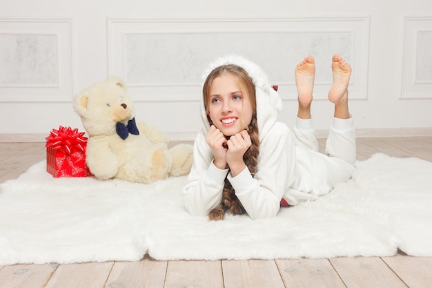 Merry Christmas and Happy New Year Beautiful happy child girl in pajamas waiting for a miracle at home with Christmas tree. Little smiling girl with christmas gift box. Holiday and people concept.