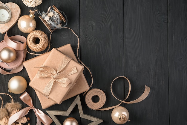 Merry Christmas and Happy New Year. Golden and beige gifts and toys on a black background. Top view, copy space.