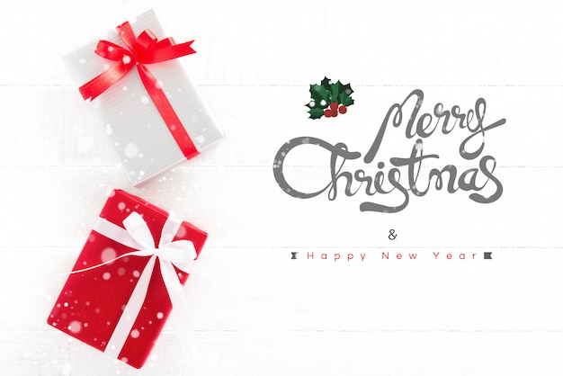 Merry Christmas and Happy New Year text with gift boxes on white wood background