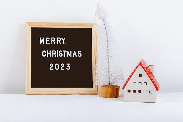 Merry Christmas lettering on letter board Eco tree minimalistic new year background 2023