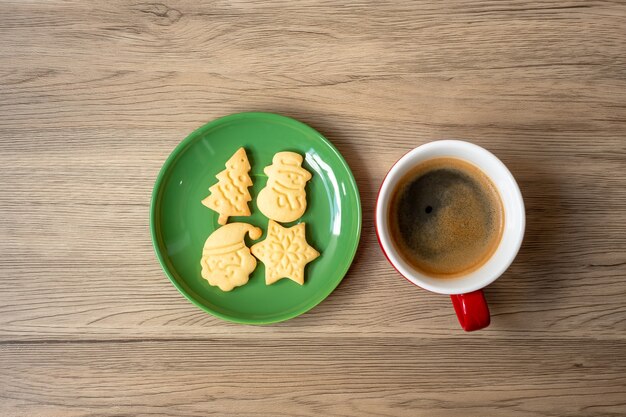 Merry Christmas with homemade cookies and coffee cup on wood table background. Xmas eve, party, holiday and happy New Year concept